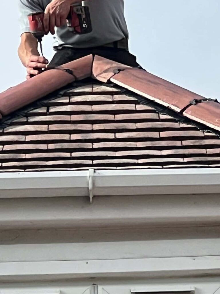 This is a photo of one of the operatives of Brandon Roofing Repairs installing new ridge tiles